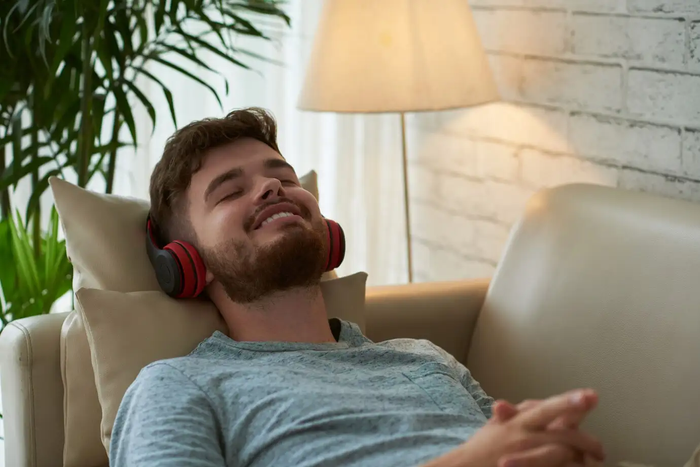 Hombre relajado en un sofá con auriculares, disfrutando de su tiempo libre. La protección laboral garantiza el bienestar del trabajador.